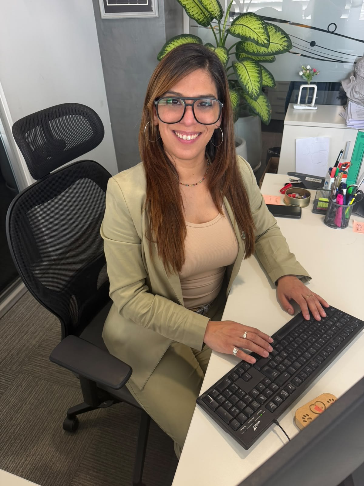 Débora Gonzalez sonriendo, trabajando en su escritorio