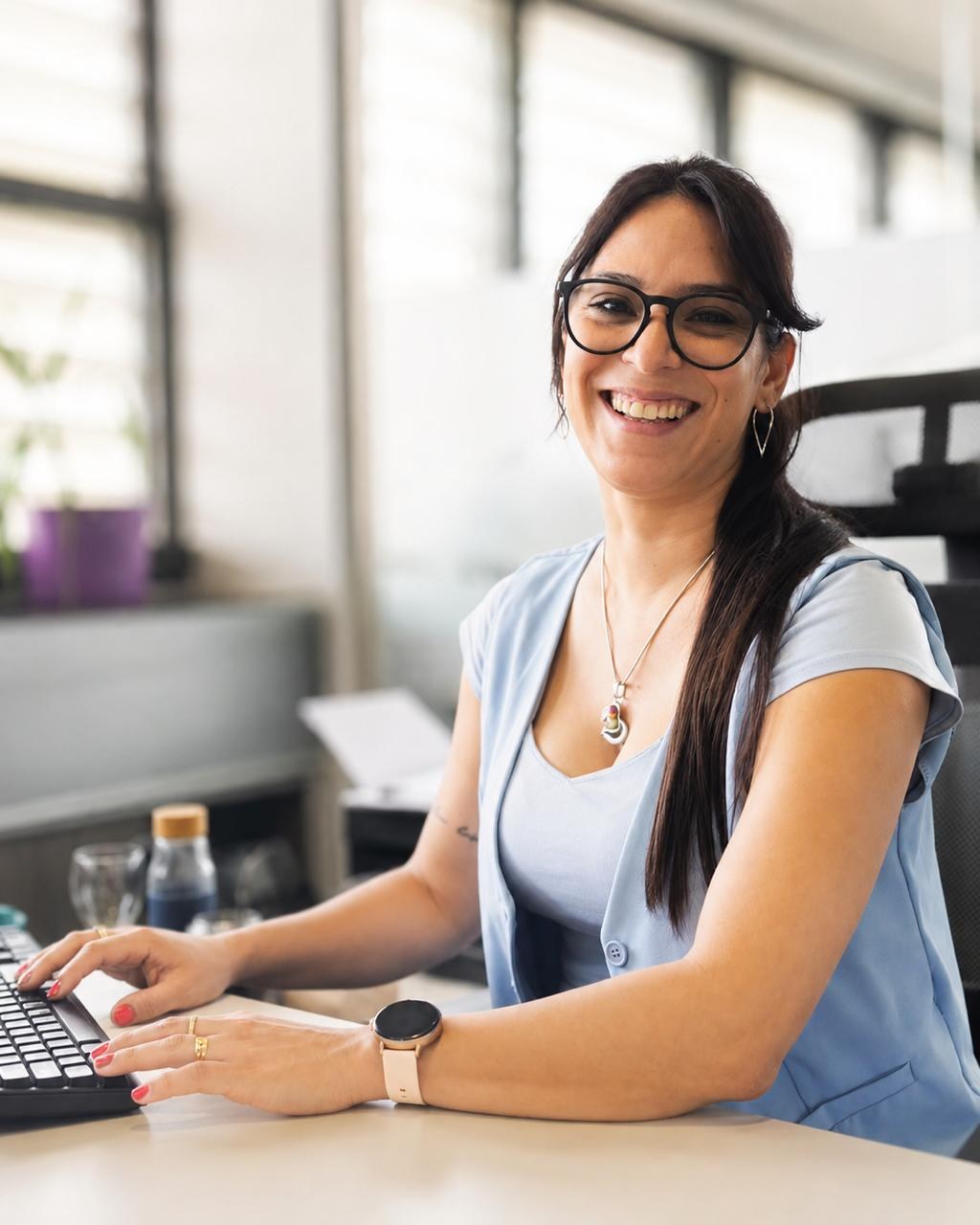 Débora Gonzalez sonriendo frente a su computadora